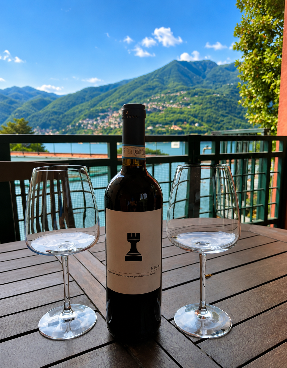 Terrace table set with wine glasses overlooking Lake Como and the mountains