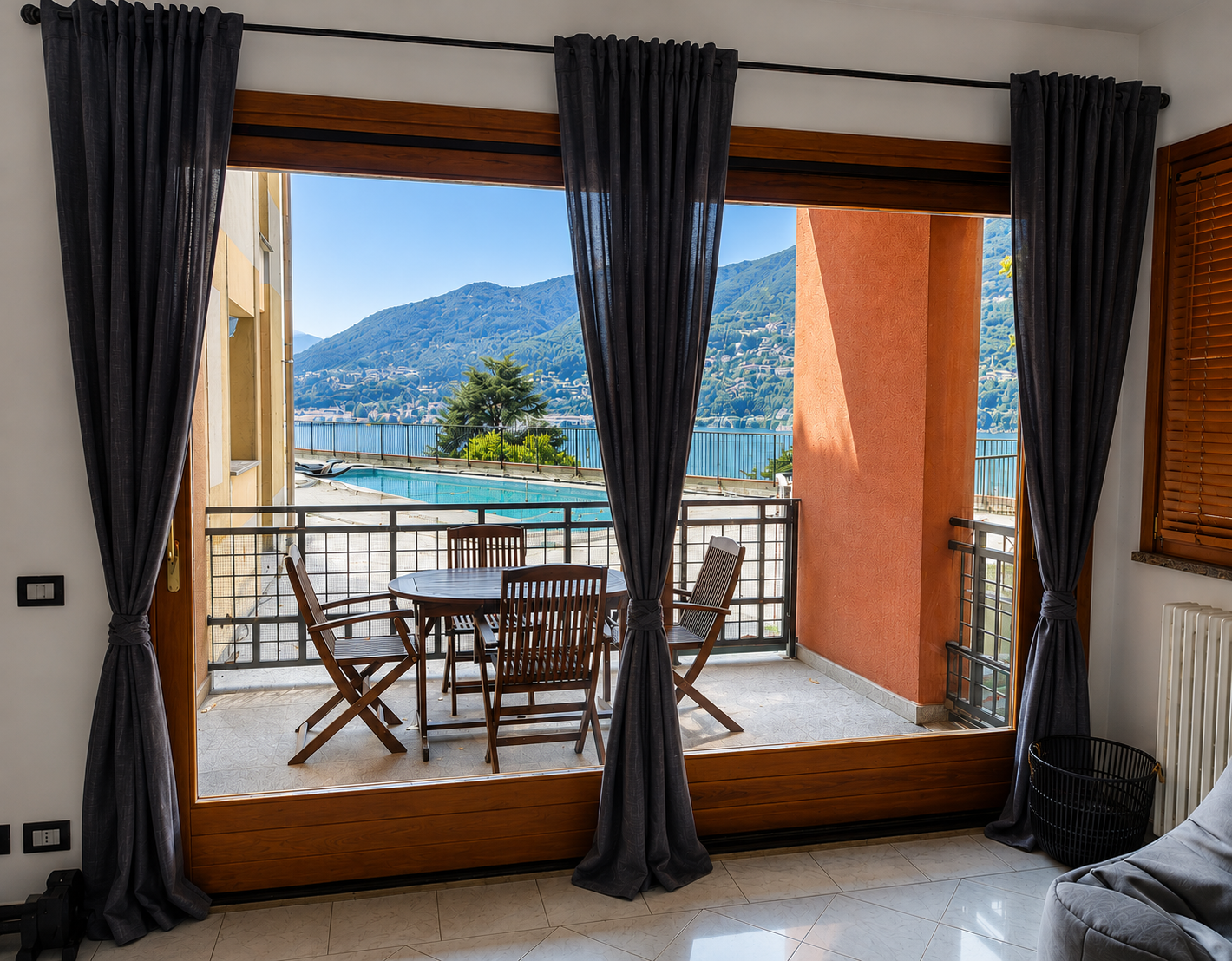 Living-room window framing the terrace, pool and Lake Como beyond