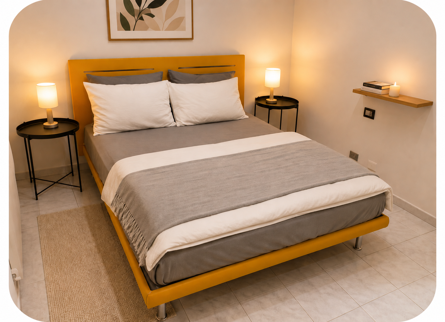Second bedroom with bold orange headboard, twin black bedside tables and warm lamp light